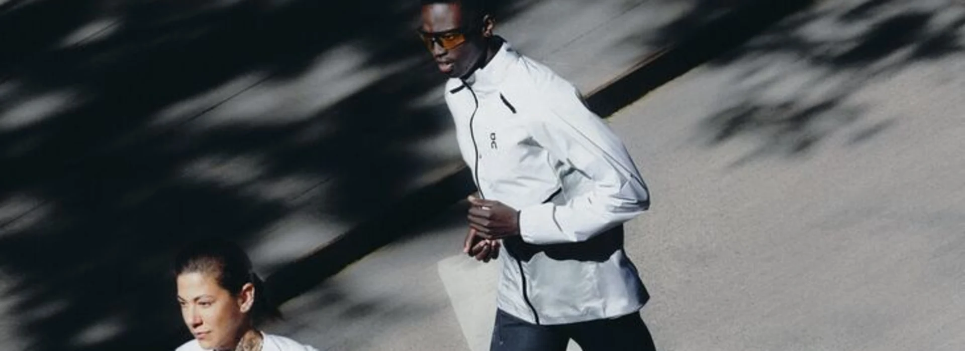 Un coureur en veste On, suivi d'autres coureurs